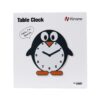 A penguin clock sitting on top of a table.