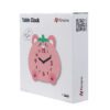 A pink table clock sitting on top of a box.