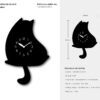 A cat clock sitting on top of the floor.